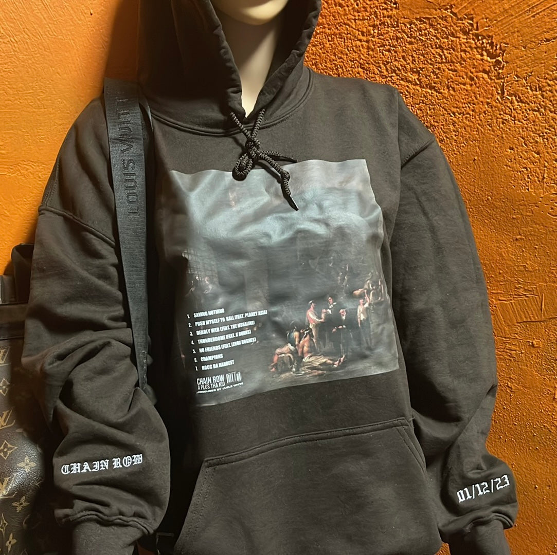 Brown hoodie with graphic design on a the front with album title & release date embroidered on sleeves.